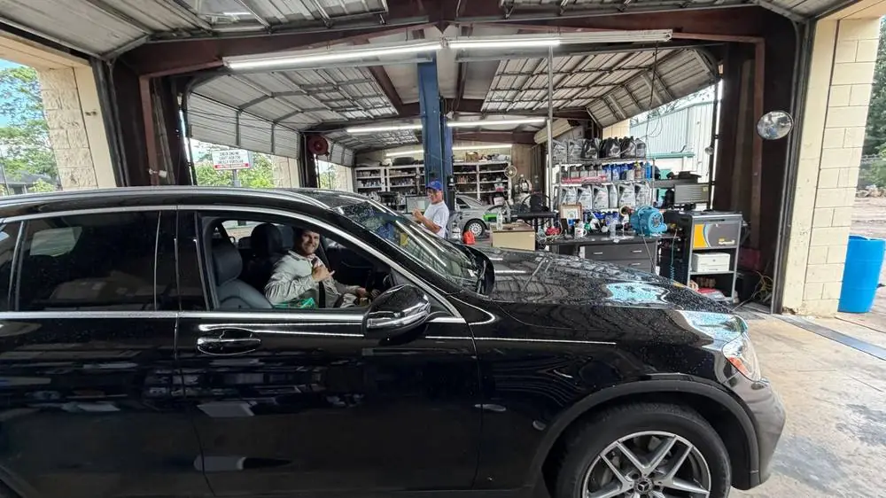 Mechanic servicing a customer's vehicle in the shop bay